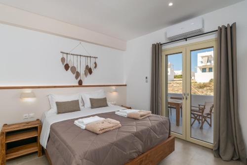 a bedroom with a large bed and a balcony at Vive Mare Milos in Pachaina