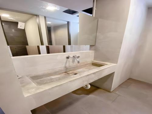 a white bathroom with a sink and a mirror at BOB INN Silom - BTS Surasak in Yan Nawa