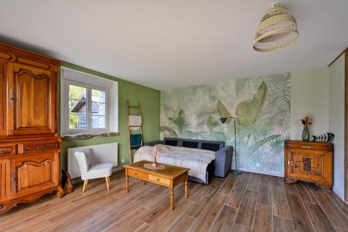 a bedroom with a bed and a table at La Maison Vert-Émeraude - Proche sentier randonnée in Arzal