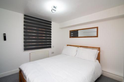 a bedroom with a white bed and a window at Bright 3 Bed Ground Floor Flat - Derby in Derby