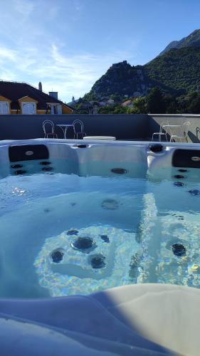 a swimming pool with blue water and chairs in it at Hotel Prvan in Vrgorac