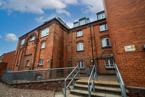 a large brick building with stairs in front of it at Bright 3 Bed Ground Floor Flat - Derby in Derby