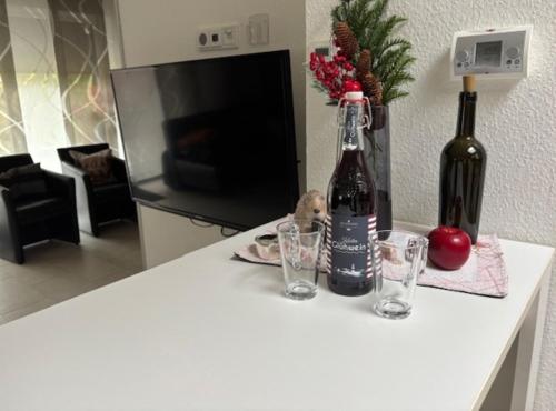a bottle of wine and two glasses on a counter at Ferienhaus 251 in Burhave in Burhave