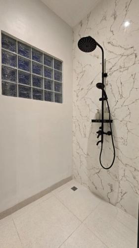 a shower in a bathroom with a stone wall at Adyatma Ubud in Ubud
