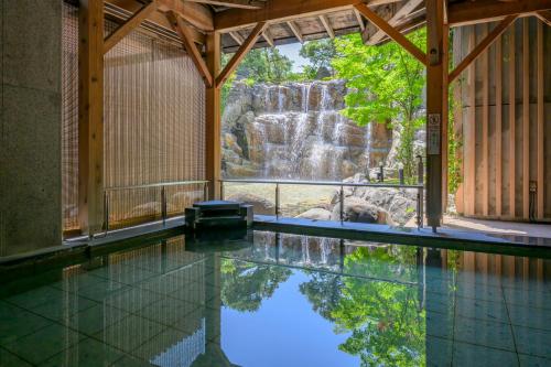 uma piscina com uma cascata ao fundo em Tendo Hotel em Tendo