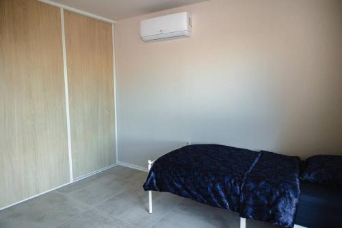 a bedroom with a bed and a air conditioner at Maison MUGUET 3 SPA-PARKING-COLMAR in Wickerschwihr