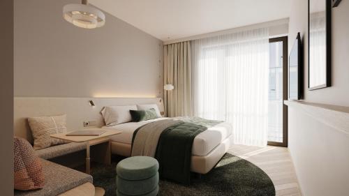 a bedroom with a bed and a living room with a couch at Bergmann's-Das Hotel in Osnabrück