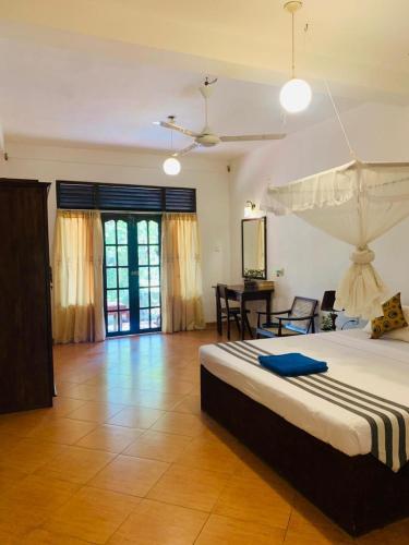 a bedroom with a large bed and a table at Westrom Villa Ocean Front in Bentota