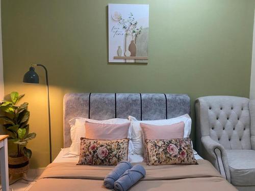 a bed with pillows and a chair in a room at D2303 Camellia Stay, Alanis Near KUL Airport in Sepang