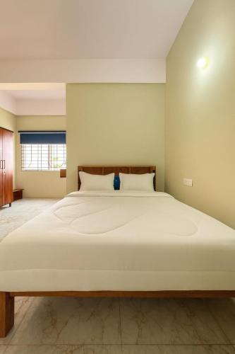 a bedroom with a large white bed in a room at Rk Resorts in Bangalore