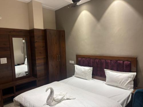 a bedroom with a bed with a swan on it at Hotel Maria in Dera Bassi