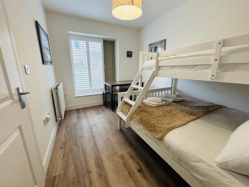 ein Schlafzimmer mit zwei Etagenbetten und einem Schreibtisch in der Unterkunft Coastal Oasis - Large Family Home in Portland