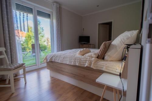 a bedroom with a bed and a large window at SILBERhERZ in Freiberg