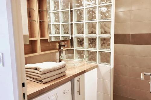 Un baño con encimera con toallas y ducha. en Bright apartment, 3 bedrooms, en Valence