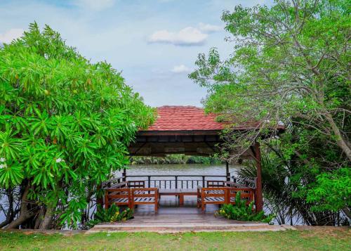 a gazebo with two benches and a table at Gin Villa in Kammala South