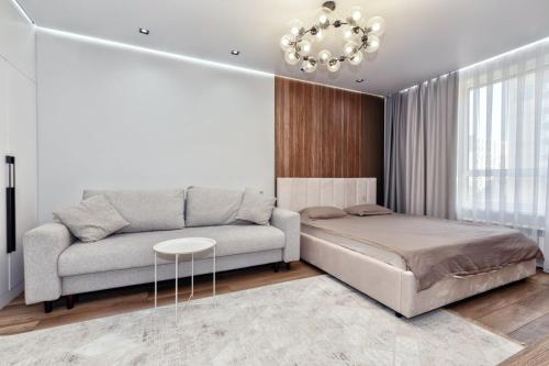 Отличный вариант рядом с Новым вокзалом في أستانا: غرفة معيشة بها أريكة وطاولة