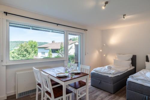 ein Zimmer mit einem Tisch und einem Bett und einem Fenster in der Unterkunft 1-Zimmerapartment Am Hochwald in Bad Liebenzell