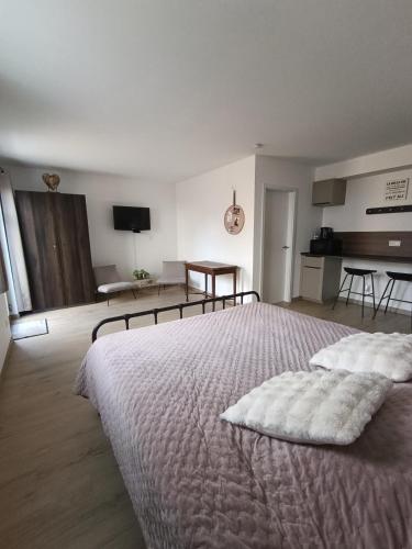 a bedroom with a large bed with white sheets at Bois de rose in Theux