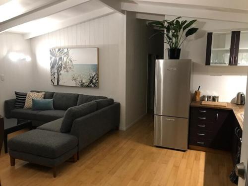 a living room with a couch and a refrigerator at Bush & Bay Hideaway in Cable Bay