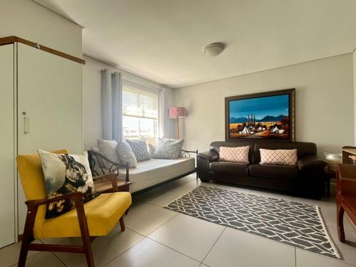 a living room with a couch and a chair at Stay on Main Garden Apartment in Paarl