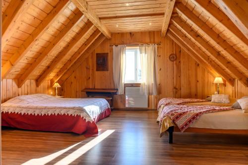 zwei Betten in einem Zimmer mit Holzwänden in der Unterkunft Gîte À L'ancienne Boulangerie in Elsenheim