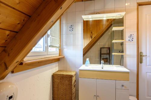 ein Badezimmer mit Waschbecken und Spiegel in der Unterkunft Gîte À L'ancienne Boulangerie in Elsenheim