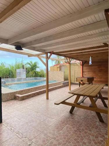 a patio with a picnic table and a pool at Appartement avec piscine à Capesterre-Belle-Eau in Capesterre-Belle-Eau