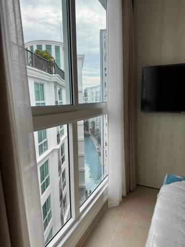 een kamer met een groot raam met uitzicht op een gebouw bij Olympus City Garden Condo Pattaya High Floor 8F in Ban Nong Chaeng