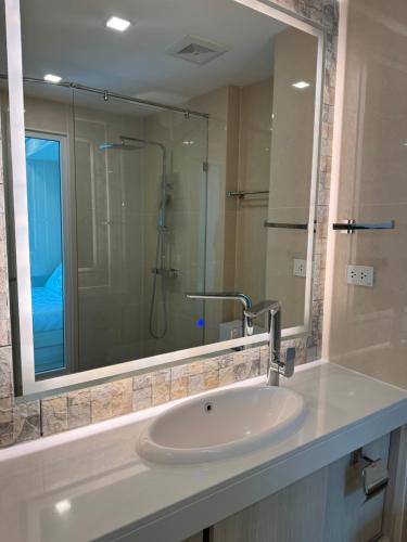 een badkamer met een wastafel en een grote spiegel bij Olympus City Garden Condo Pattaya High Floor 8F in Ban Nong Chaeng