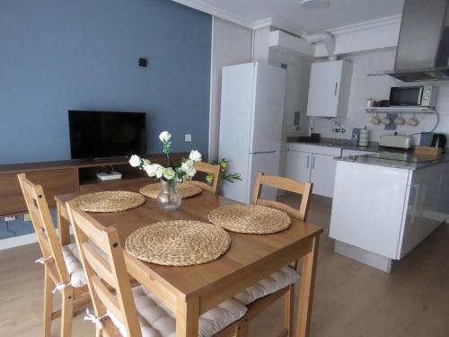 une cuisine avec une table en bois et des chaises ainsi qu'une salle à manger dans l'établissement La Casina Poniente,cerca de la playa, à Gijón