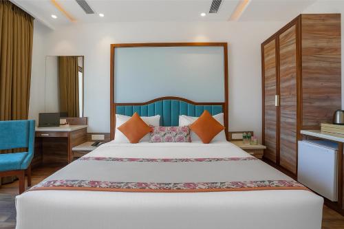 アムリトサルにあるHotel Amrit viewの大きなベッドと机のある寝室