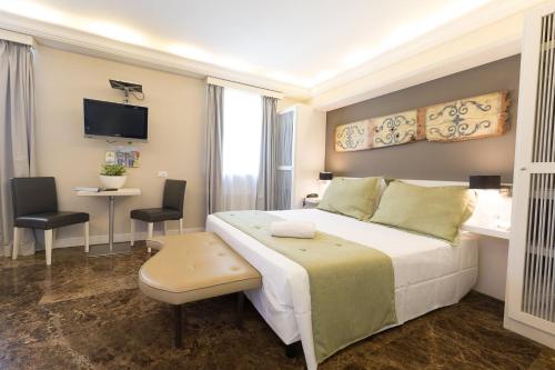 a bedroom with a large white bed and a desk at Quintocanto Hotel & Spa in Palermo