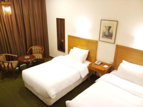 Postel nebo postele na pokoji v ubytování OrientalPalace Hotel