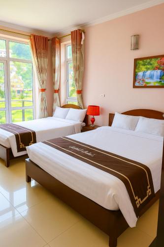 a bedroom with two beds and a window at Orient Tam Đảo Hotel in Tam Ðảo