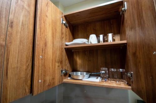 Una cocina con gabinetes de madera y un fregadero. en Rustic Studio with free WI-FI, en Nanyuki