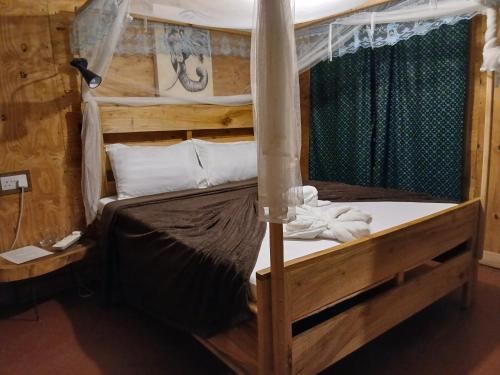 a bedroom with a wooden bunk bed with white sheets at Patience Airport cottages in Boma la Ngombe