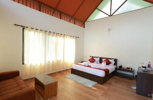 a bedroom with a bed and a couch at Prakrithi Luxe Retreat in Padinjarathara