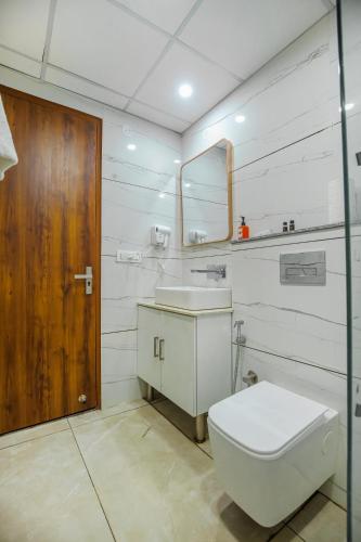 a bathroom with a toilet and a sink and a mirror at Hotel Hiltane Opposite VR Punjab Mall Airport Road Mohali Chandigarh in Kharar