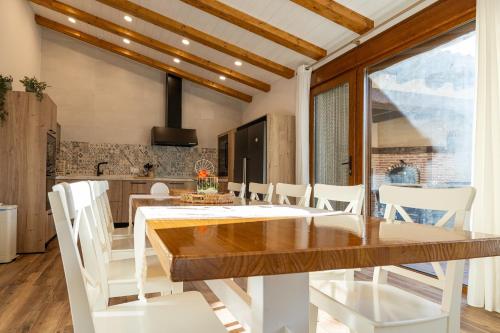 a kitchen and dining room with a wooden table and white chairs at Casa Teresa in La Santa Espina