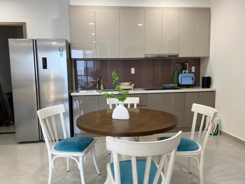 a kitchen with a table and chairs and a refrigerator at Nghỉ dưỡng MT Eastmark in Xóm Ðội Bảy Ti