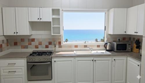 a white kitchen with a view of the ocean at Roof top in Hammamet