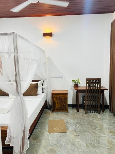 a bedroom with a bed and a wooden table at Dimuthu Green Villa in Sigiriya
