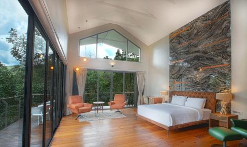 a bedroom with a bed and a large window at Stanley Revelation in Attigundi