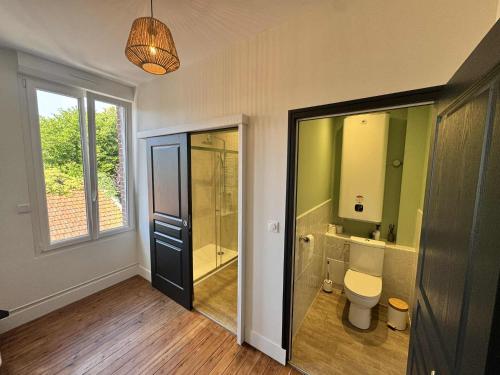 a bathroom with a toilet and a walk in shower at Maison Entre Verre et Mer in Eu