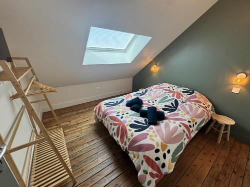 a bedroom with a bed in a room with a skylight at Maison Entre Verre et Mer in Eu