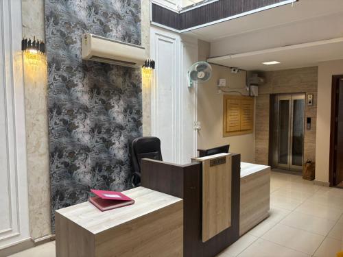 a reception desk in a room with a wall at Hotel Maria in Dera Bassi