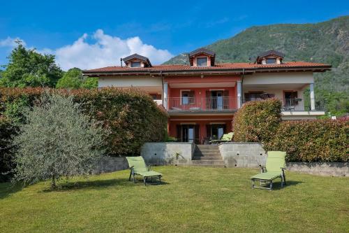 a house with two chairs in the yard at Villetta dei Pascoli in Baveno
