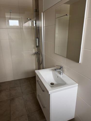 a white bathroom with a sink and a mirror at Stadtquartier Völkermarkt in Völkermarkt