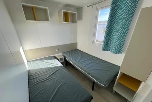 En eller flere senge i et værelse på Mobil home G107 Camping les VIGNES Lit-et-Mixe