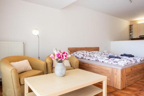 una camera con un letto e un vaso di fiori su un tavolo di Apartmán IRIS Poděbrady 3 a Poděbrady